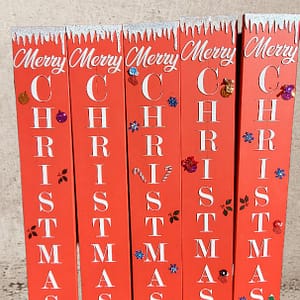 vertical red Christmas porch sign with decorations