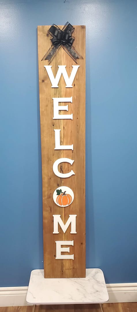 orange pumpkin on vertical welcome sign