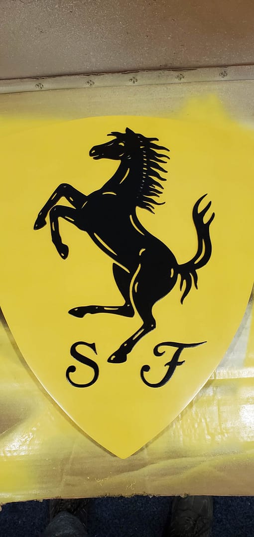 black Ferrari horse on yellow sign