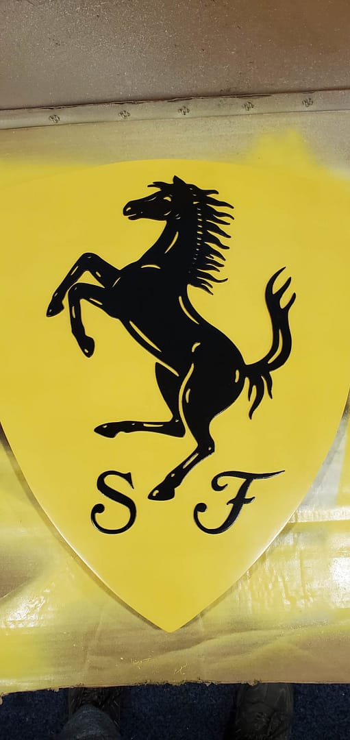 black Ferrari horse on yellow sign