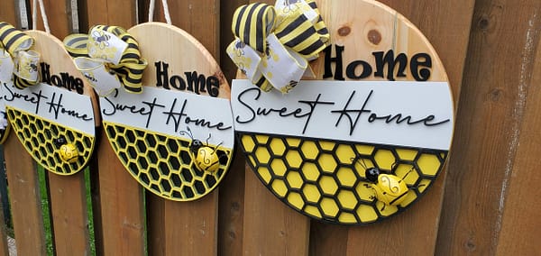 Yellow metal bee on a wood sign with yellow ribbon